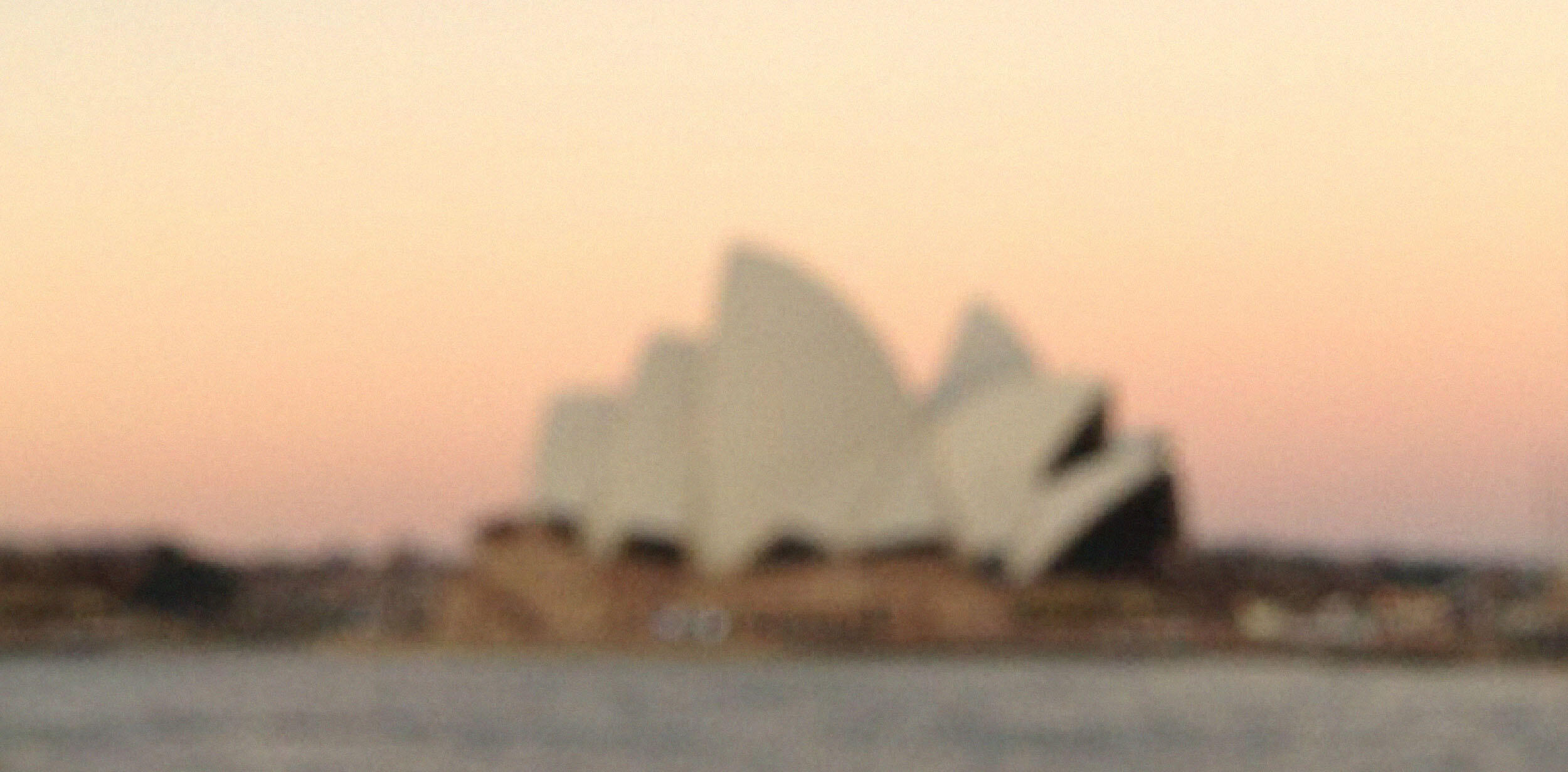 Out of focus photograph of the Sydney Opera House sails at sunrise.