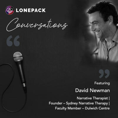 Composite image of a microphone on a grey background with an image of a smiling man with dark hair in the upper right corner.